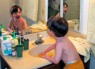 Jack at the bathroom sink reflected in the mirrors